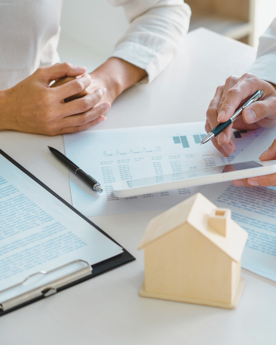 Advisors reviewing real estate financial reports with a property model on the desk